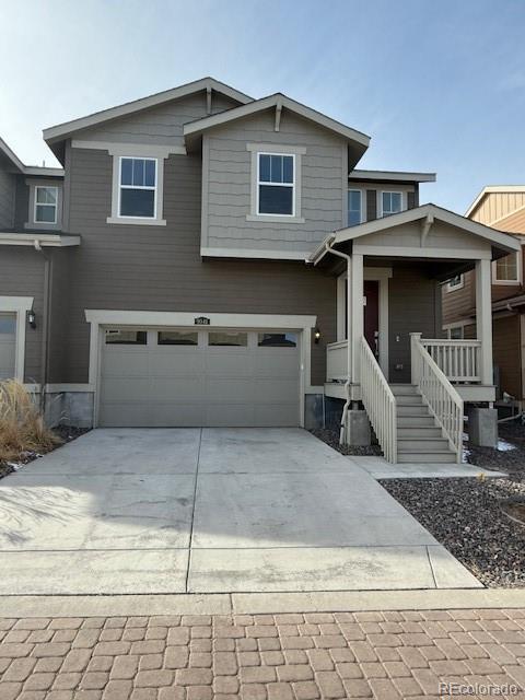 view of front of house with a porch, an attached garage, and driveway