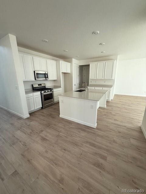 kitchen featuring white cabinets, light wood-style flooring, and stainless steel appliances