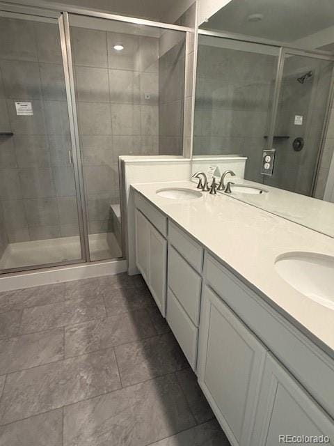 full bath featuring a shower stall, double vanity, and a sink