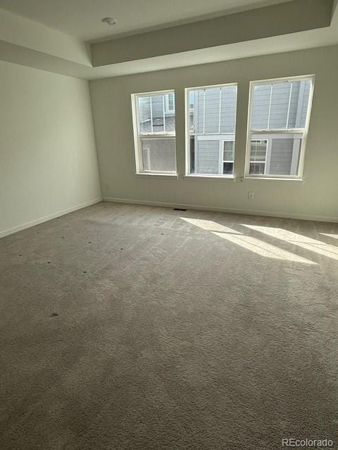 spare room with carpet and baseboards