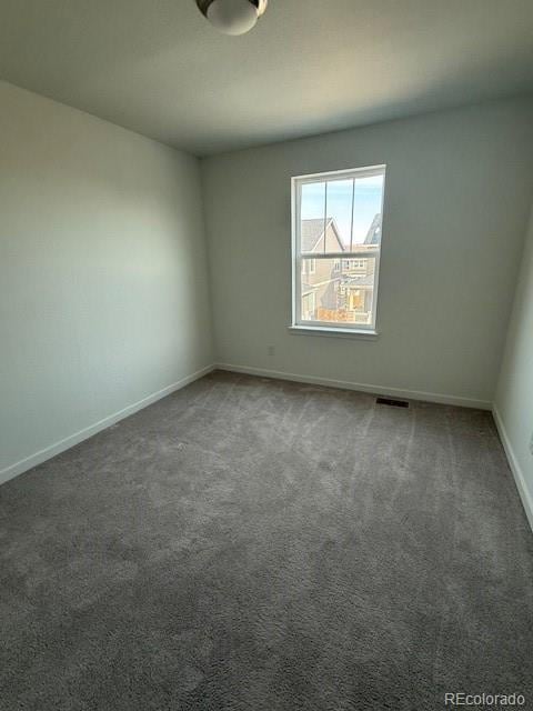 unfurnished room with visible vents, baseboards, and carpet floors