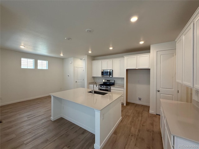 9041 Redfield Ln, Parker, CO 80134 - kitchen featuring appliances with stainless steel finishes, a sink, light wood-style floors, white cabinets, and baseboards