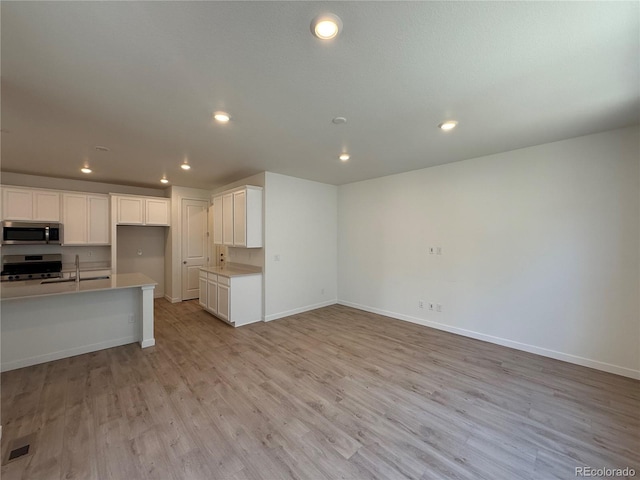 9041 Redfield Ln, Parker, CO 80134 - kitchen featuring stainless steel appliances, a sink, light wood-style flooring, baseboards, and recessed lighting