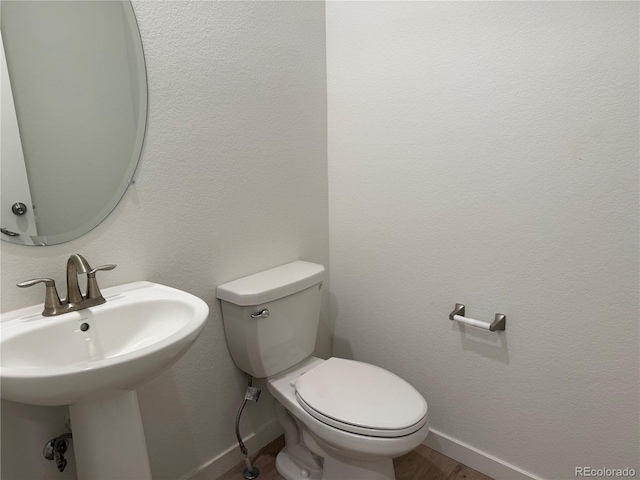 9041 Redfield Ln, Parker, CO 80134 - bathroom featuring baseboards, toilet, wood finished floors, and a sink