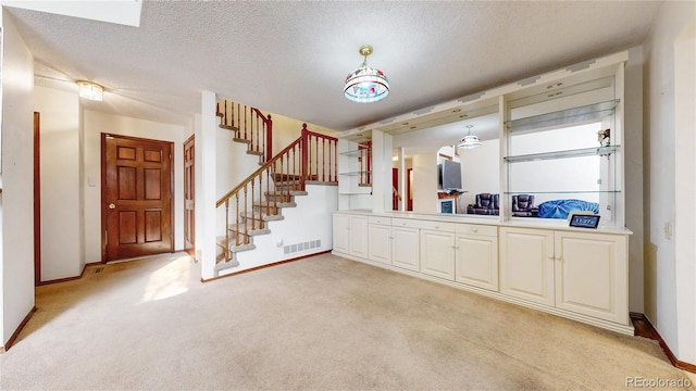 interior space featuring a textured ceiling, visible vents, and baseboards