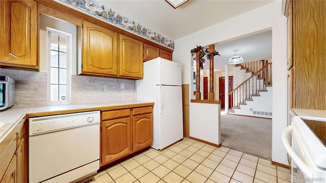 kitchen with light colored carpet, white appliances, visible vents, decorative backsplash, and brown cabinetry