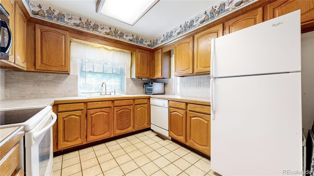 kitchen featuring light countertops, white appliances, brown cabinetry, and a sink