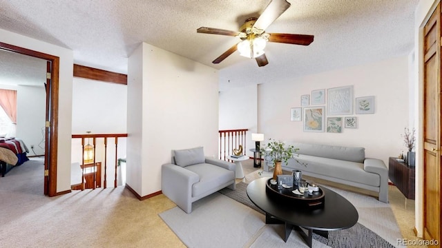 living area with baseboards, a textured ceiling, and light colored carpet