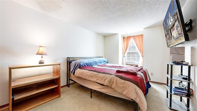 carpeted bedroom with baseboards and a textured ceiling