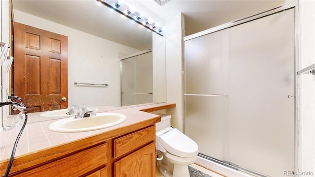 bathroom featuring a stall shower, vanity, and toilet