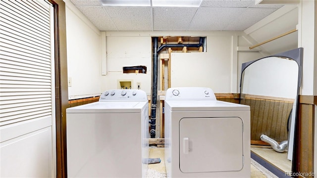 clothes washing area with laundry area, washer and clothes dryer, and a wainscoted wall