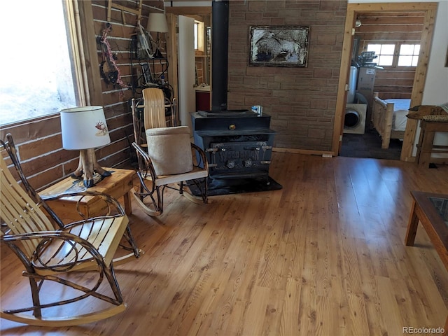 living area with a wood stove and wood-type flooring