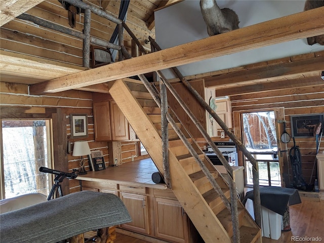 stairs featuring beamed ceiling, wood-type flooring, and wooden ceiling