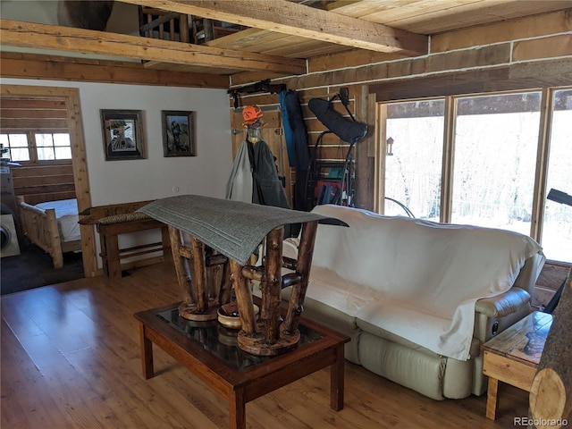 living room with beamed ceiling, a healthy amount of sunlight, and hardwood / wood-style flooring
