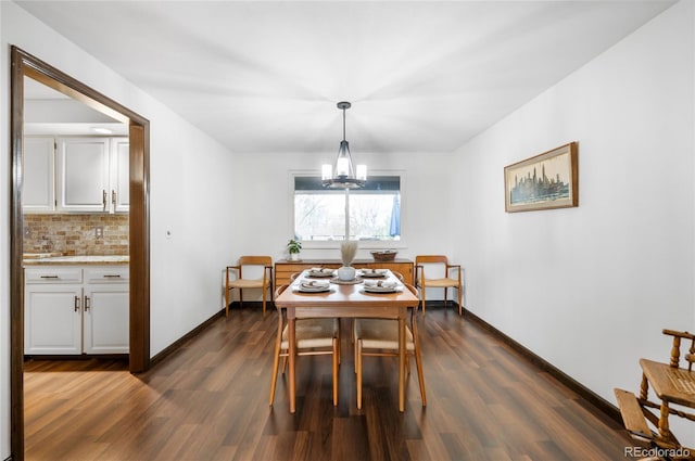 dining room featuring baseboards, dark wood-type flooring, and a chandelier
