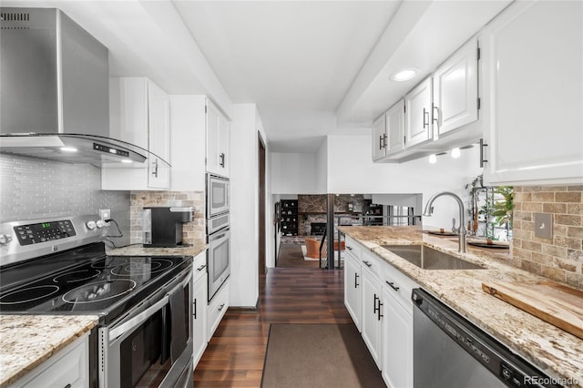 kitchen featuring tasteful backsplash, a sink, stainless steel appliances, wall chimney exhaust hood, and dark wood-type flooring