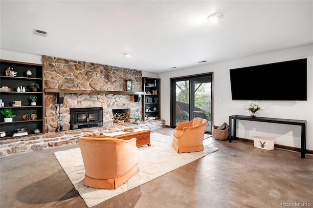living room featuring built in features, a fireplace, concrete flooring, and visible vents