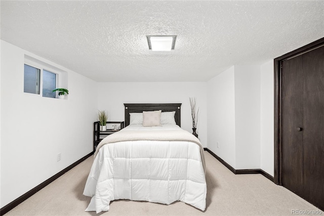 bedroom featuring baseboards, carpet, and a textured ceiling