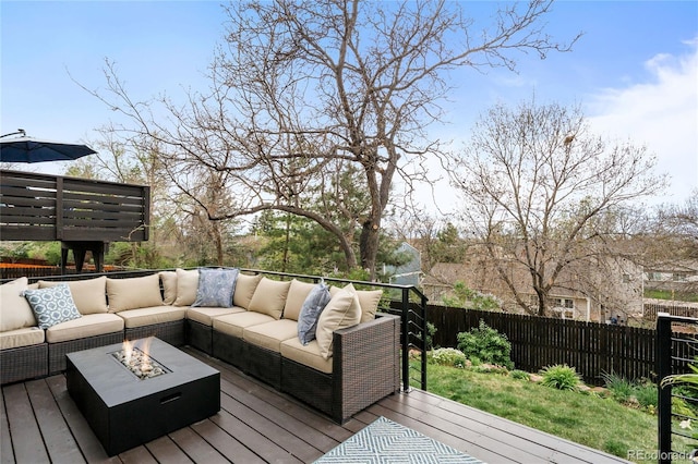 wooden terrace featuring a fenced backyard and an outdoor living space with a fire pit