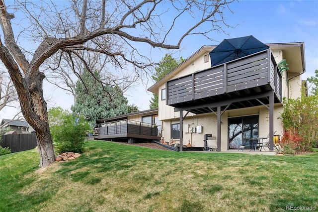 rear view of house featuring fence, brick siding, a wooden deck, board and batten siding, and a yard