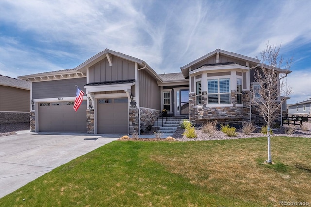 craftsman-style house featuring an attached garage, stone siding, board and batten siding, a front yard, and concrete driveway