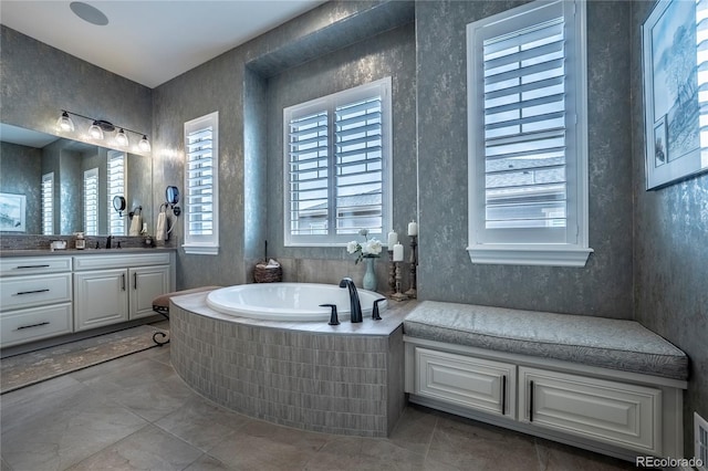 bathroom with tile patterned floors, a bath, and vanity