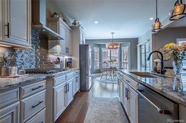 kitchen featuring a sink, appliances with stainless steel finishes, recessed lighting, and wall chimney exhaust hood