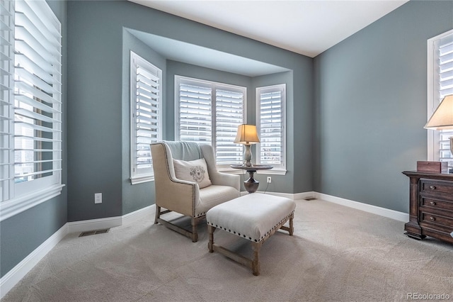 sitting room featuring baseboards, visible vents, and carpet