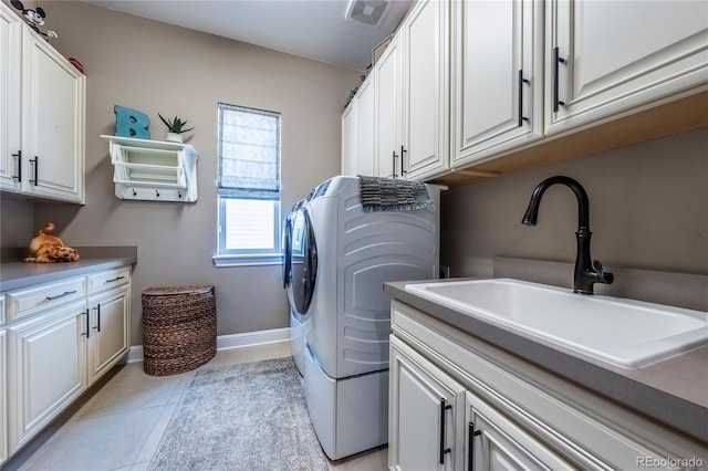 washroom featuring visible vents, separate washer and dryer, a sink, cabinet space, and light tile patterned floors
