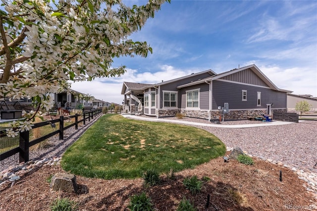 exterior space featuring fence, a front yard, and stone siding