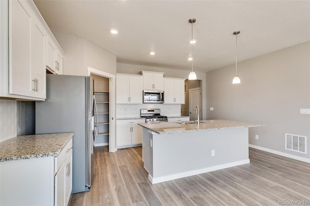 kitchen featuring pendant lighting, sink, stainless steel appliances, and white cabinets