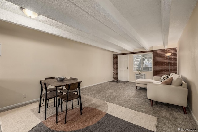 dining area featuring beamed ceiling, carpet floors, and a textured ceiling