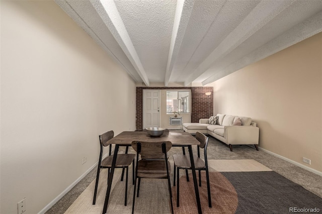 carpeted dining space featuring beam ceiling and a textured ceiling