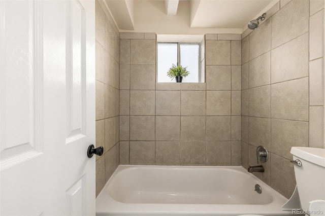 bathroom with tiled shower / bath and toilet