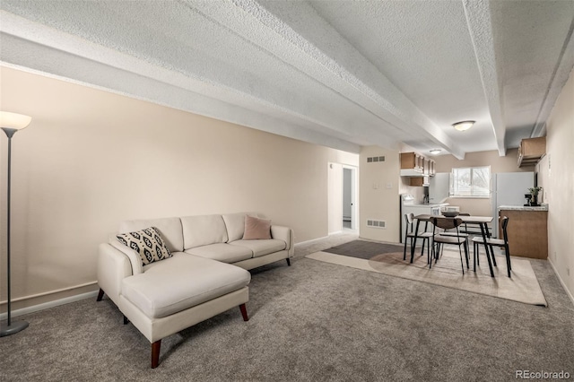 carpeted living room featuring a textured ceiling