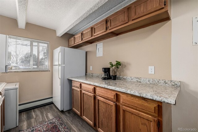1180 Yosemite St Unit 104, Denver, CO 80220 - kitchen with freestanding refrigerator, a textured ceiling, a baseboard heating unit, brown cabinetry, and light countertops