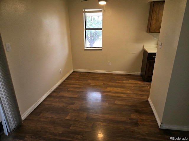 unfurnished dining area with ceiling fan and dark hardwood / wood-style floors