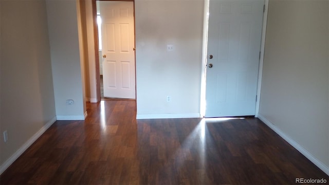 unfurnished room with dark hardwood / wood-style flooring