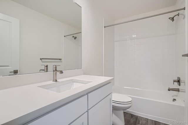 full bathroom with hardwood / wood-style floors, bathing tub / shower combination, vanity, and toilet