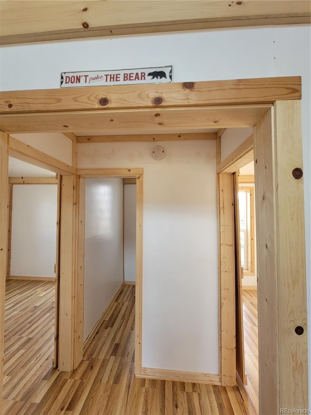 hallway with light hardwood / wood-style floors