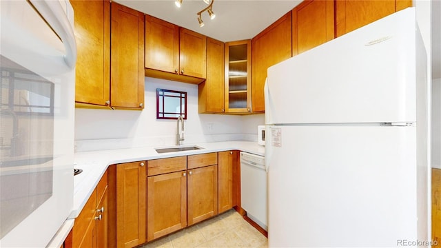 kitchen featuring light tile patterned flooring, sink, track lighting, and white appliances