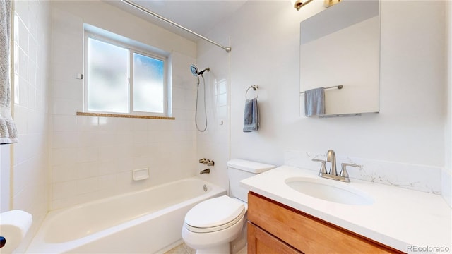 full bathroom featuring vanity, tiled shower / bath combo, and toilet