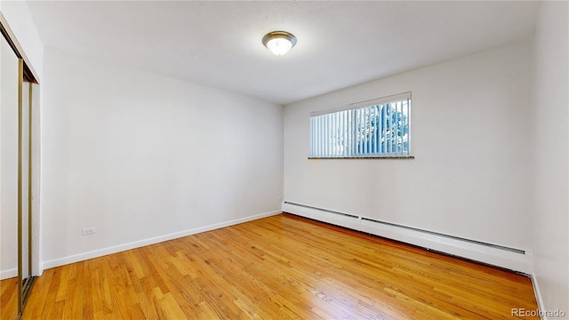 unfurnished room featuring light hardwood / wood-style flooring and baseboard heating