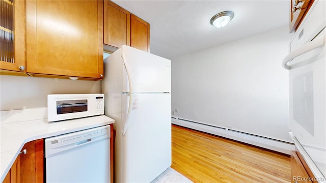 kitchen with a baseboard heating unit, white appliances, and light hardwood / wood-style floors