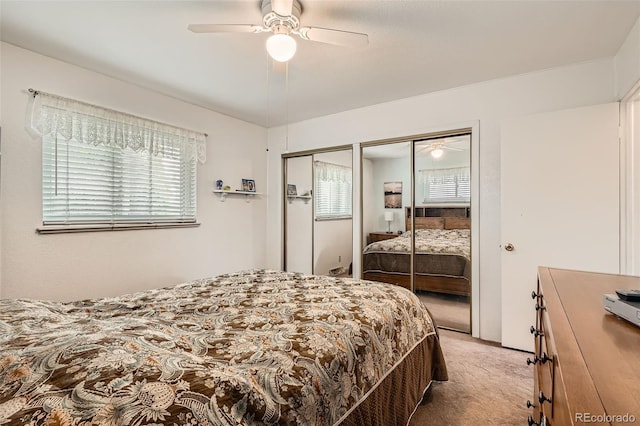 carpeted bedroom featuring two closets and ceiling fan