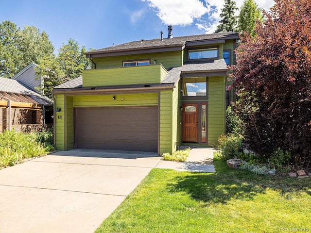 view of front of home with a front lawn and a garage