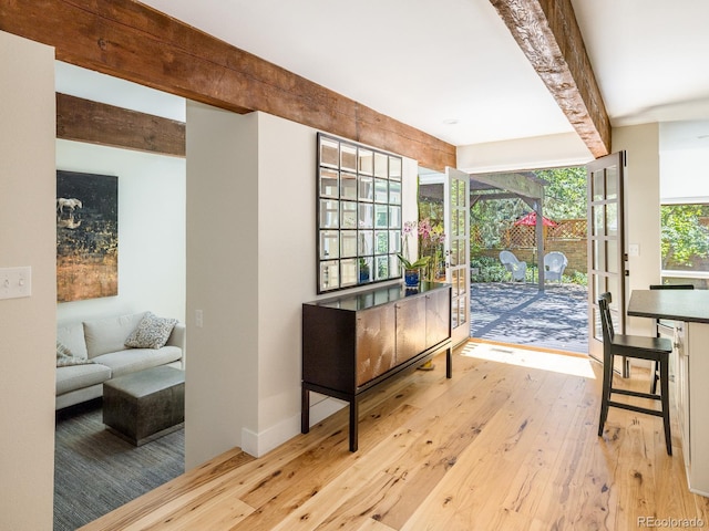 interior space with beamed ceiling, light hardwood / wood-style floors, and plenty of natural light