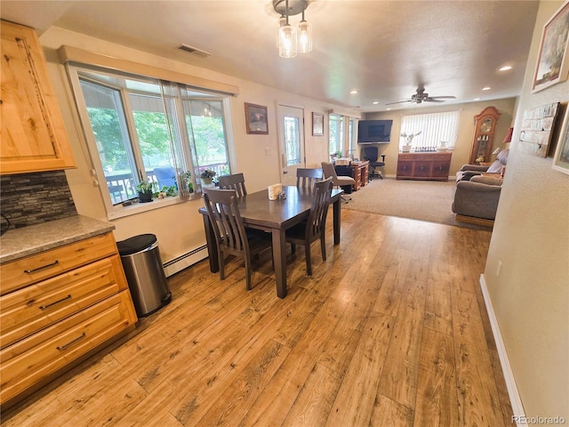 720 W 4th St, Julesburg, CO 80737 - dining area with a baseboard radiator, light wood-style floors, recessed lighting, baseboards, and a ceiling fan
