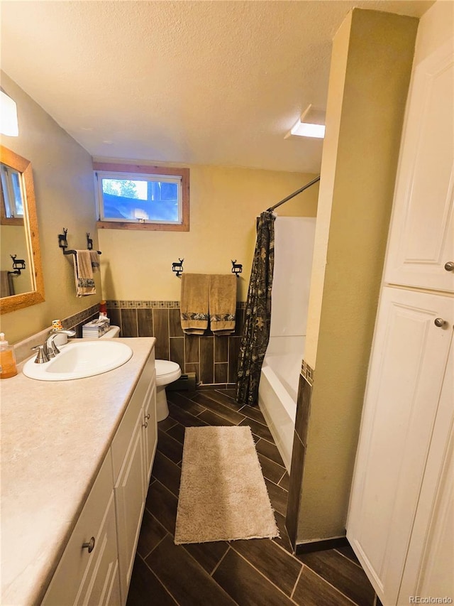 720 W 4th St, Julesburg, CO 80737 - bathroom featuring vanity, a textured ceiling, toilet, and shower / tub combo with curtain