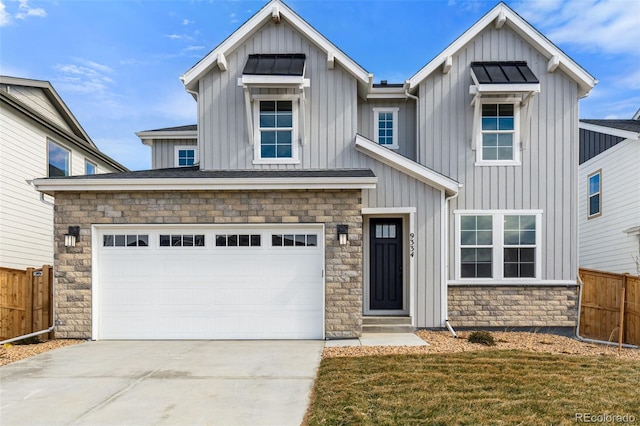 modern farmhouse style home with board and batten siding, concrete driveway, stone siding, and fence